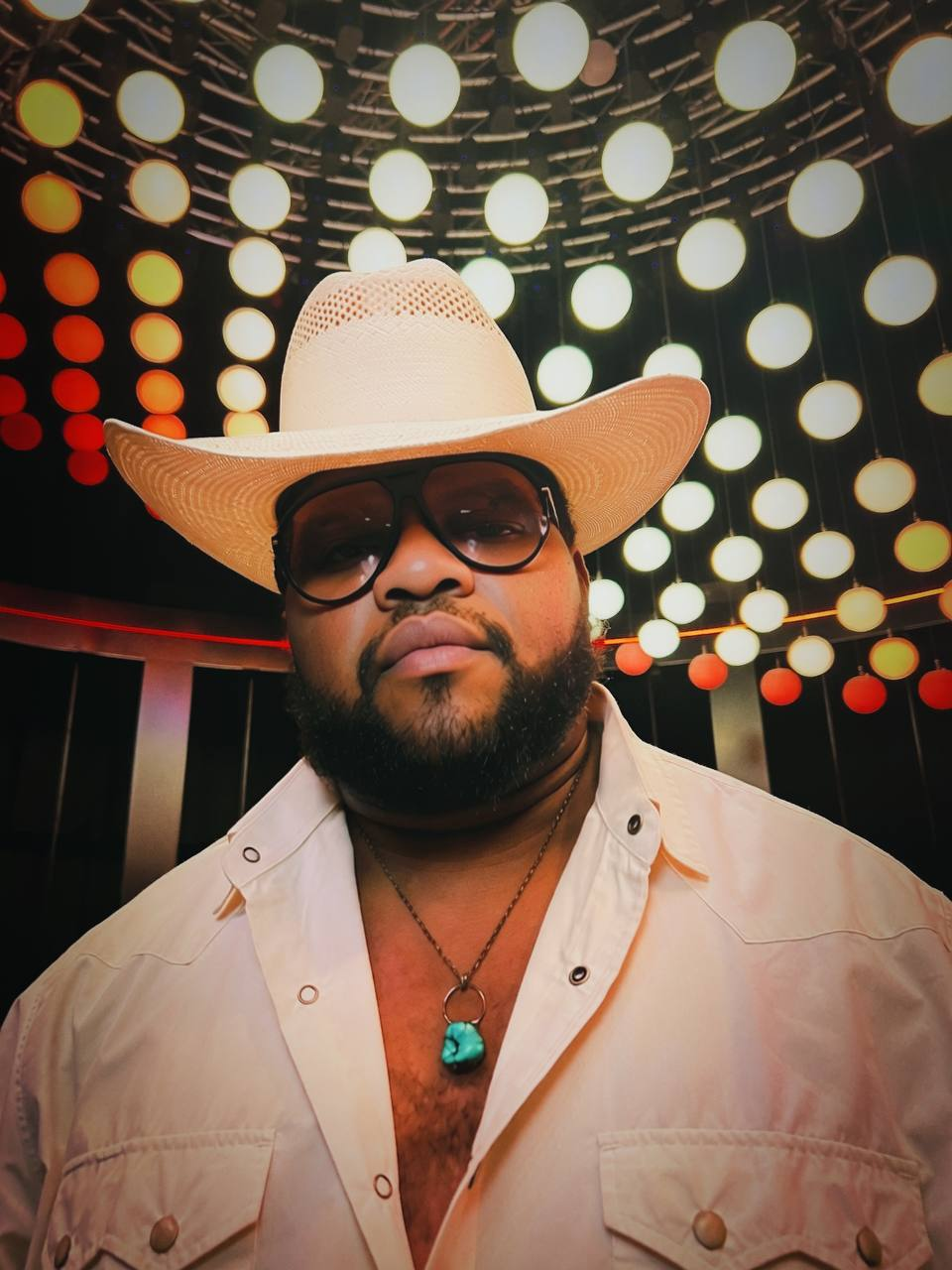 Duncan Daniels in a straw Stetson beneath amber stage lights